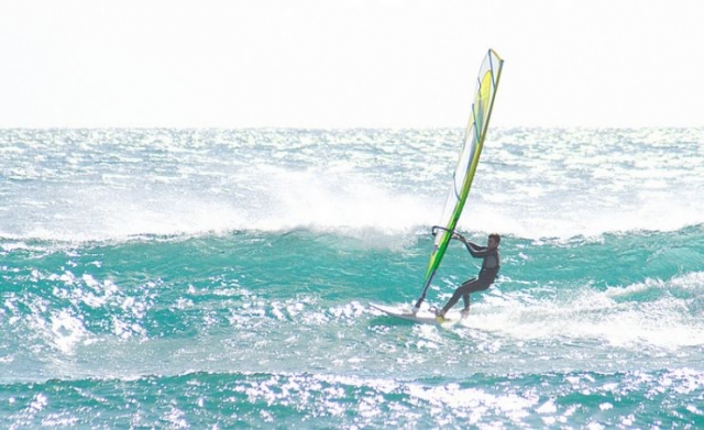 chico practicando windsurf en el mar